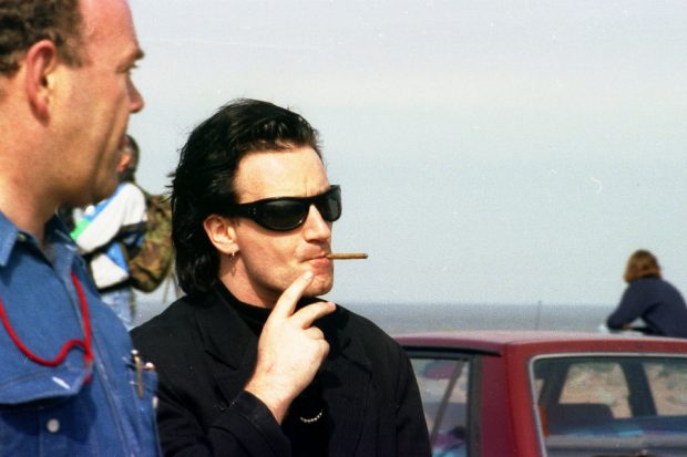 The rock star 'Bono' on Seascale beach smoking a cigar 