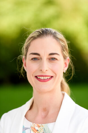 Emma-Jayne Gooch smiling into the camera on a sunny day outside