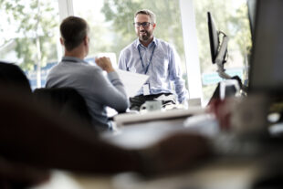 Two Sellafield employees talking to one another in an office environment