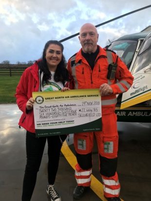 Sophie kelly presenting a cheque to the North West Air Ambulance.