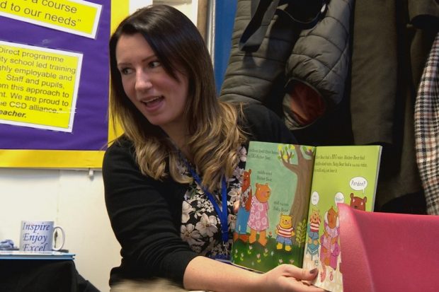 Rebecca Ballantyne sitting down reading a story to children