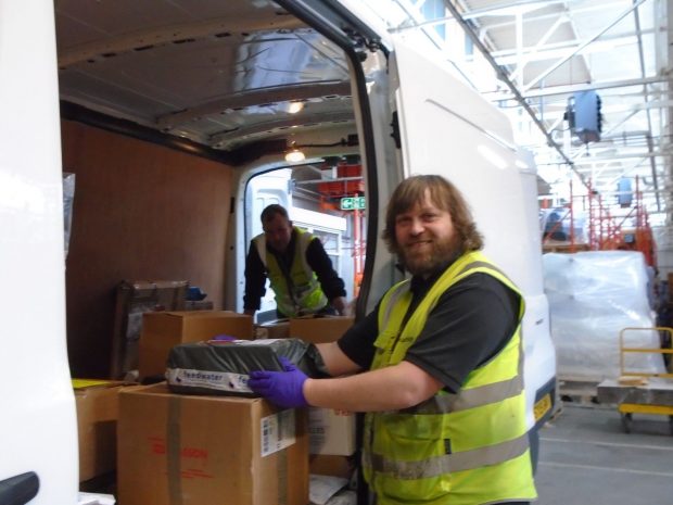 A man loads up boxes of personal protective equipment into a van