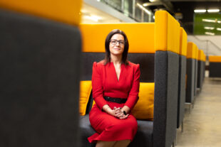 NWS CEO Corhyn Parr sitting on a sofa in red dress