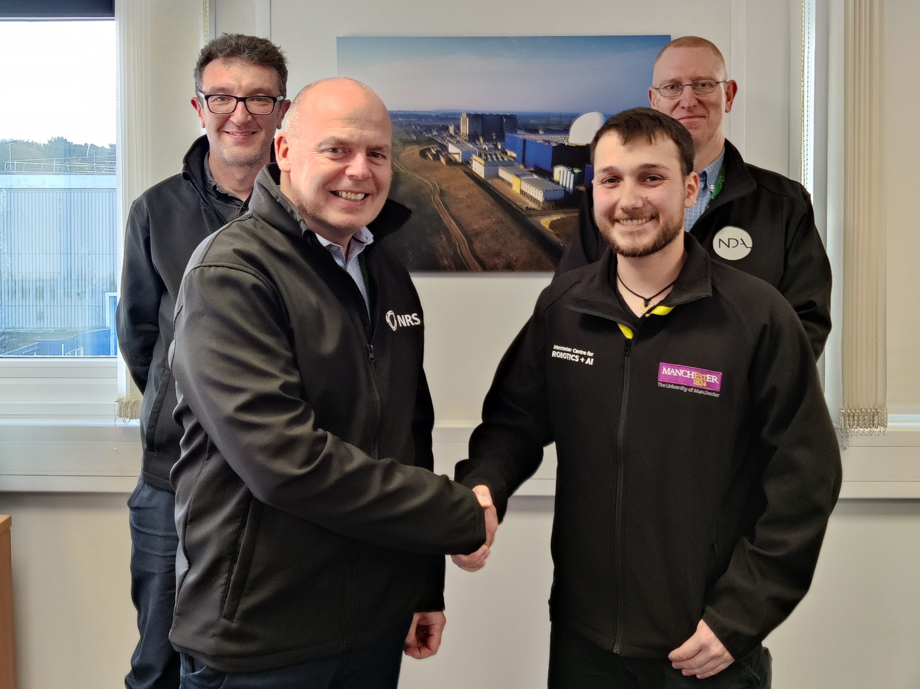 Joshua Bettles pictured with three people from NDA and NRS who arranged his work placement